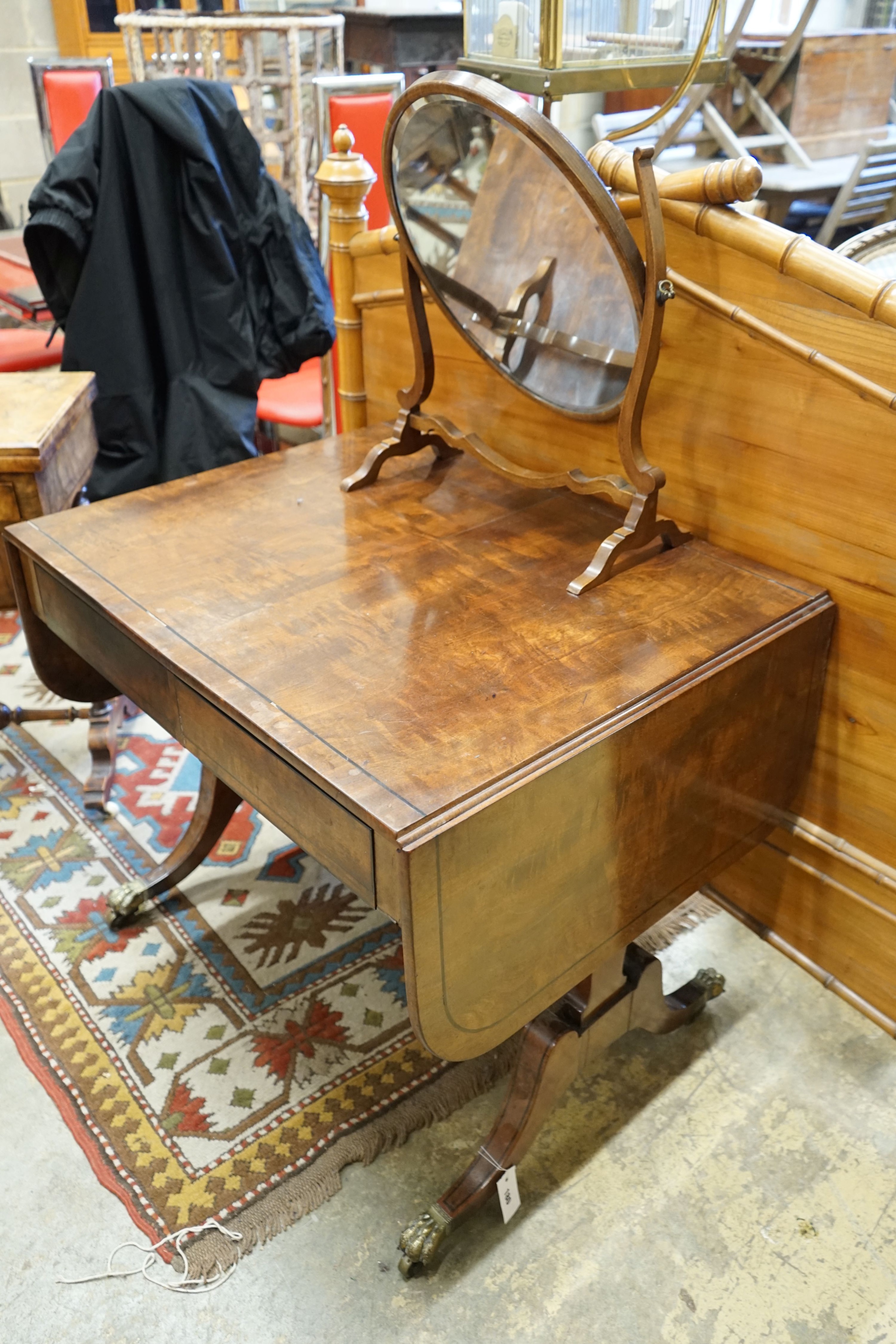 A Regency figured mahogany and ebony strung sofa table, width 83cm depth 66cm height 72cm, and a skeleton toilet mirror